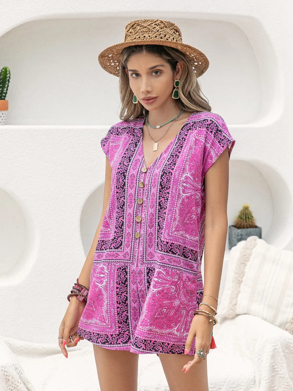 Pink printed v-neck cap sleeve romper with decorative trim at neckline