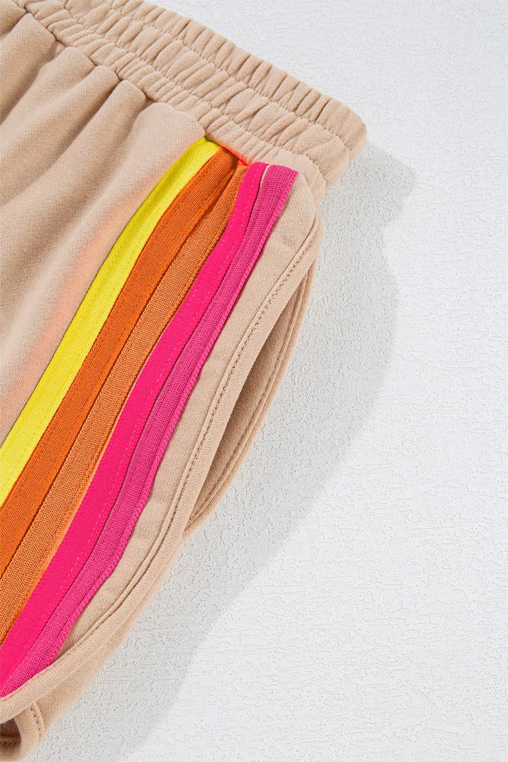 Tan shorts waistband with rainbow striped side panel and elastic cuff