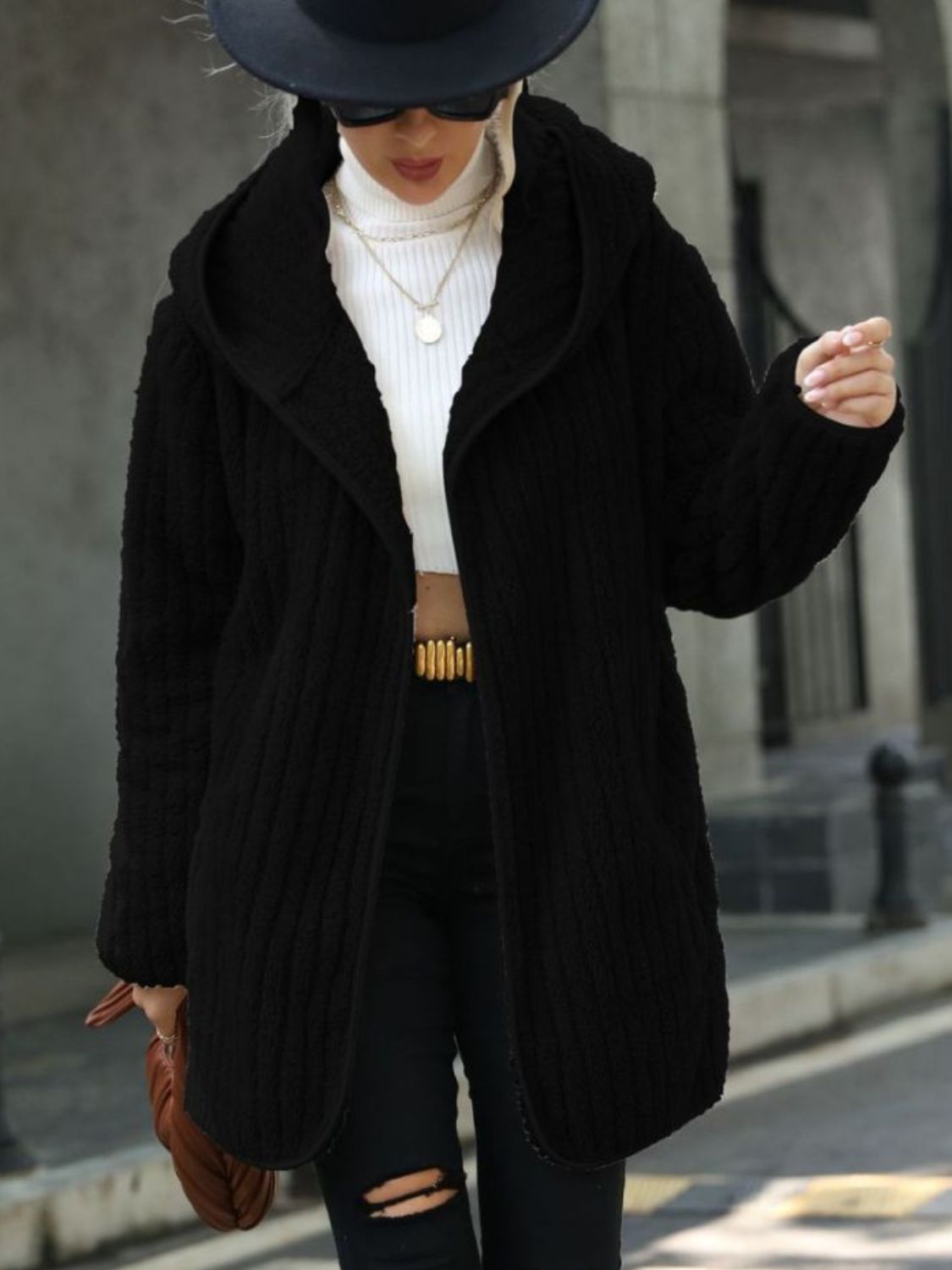 Black ribbed hooded open-front coat close-up, showing textured knit and front opening