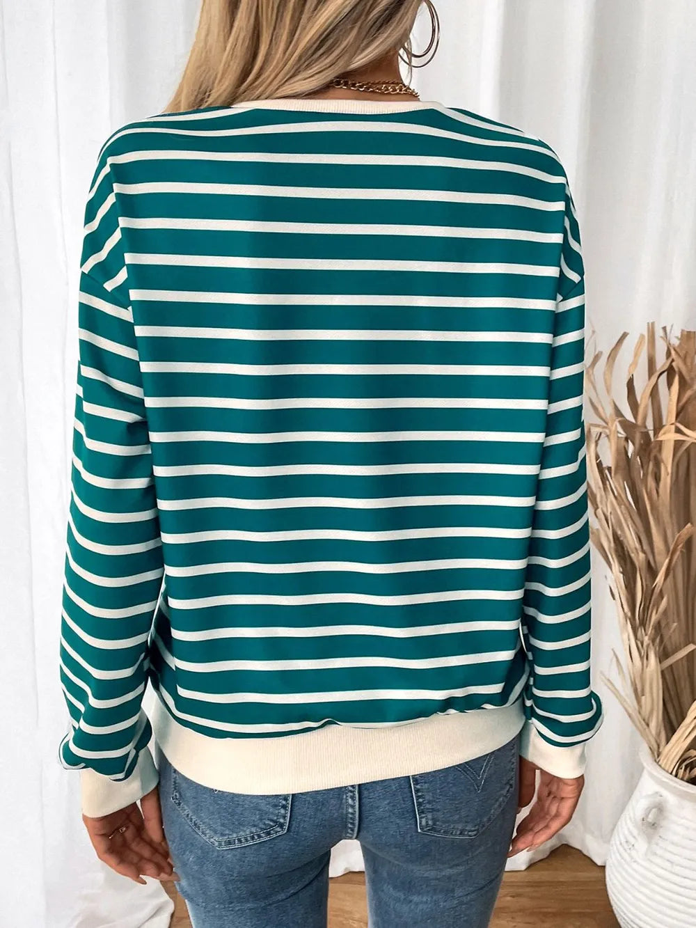 Back view of turquoise and white striped long-sleeve sweatshirt with contrast hem