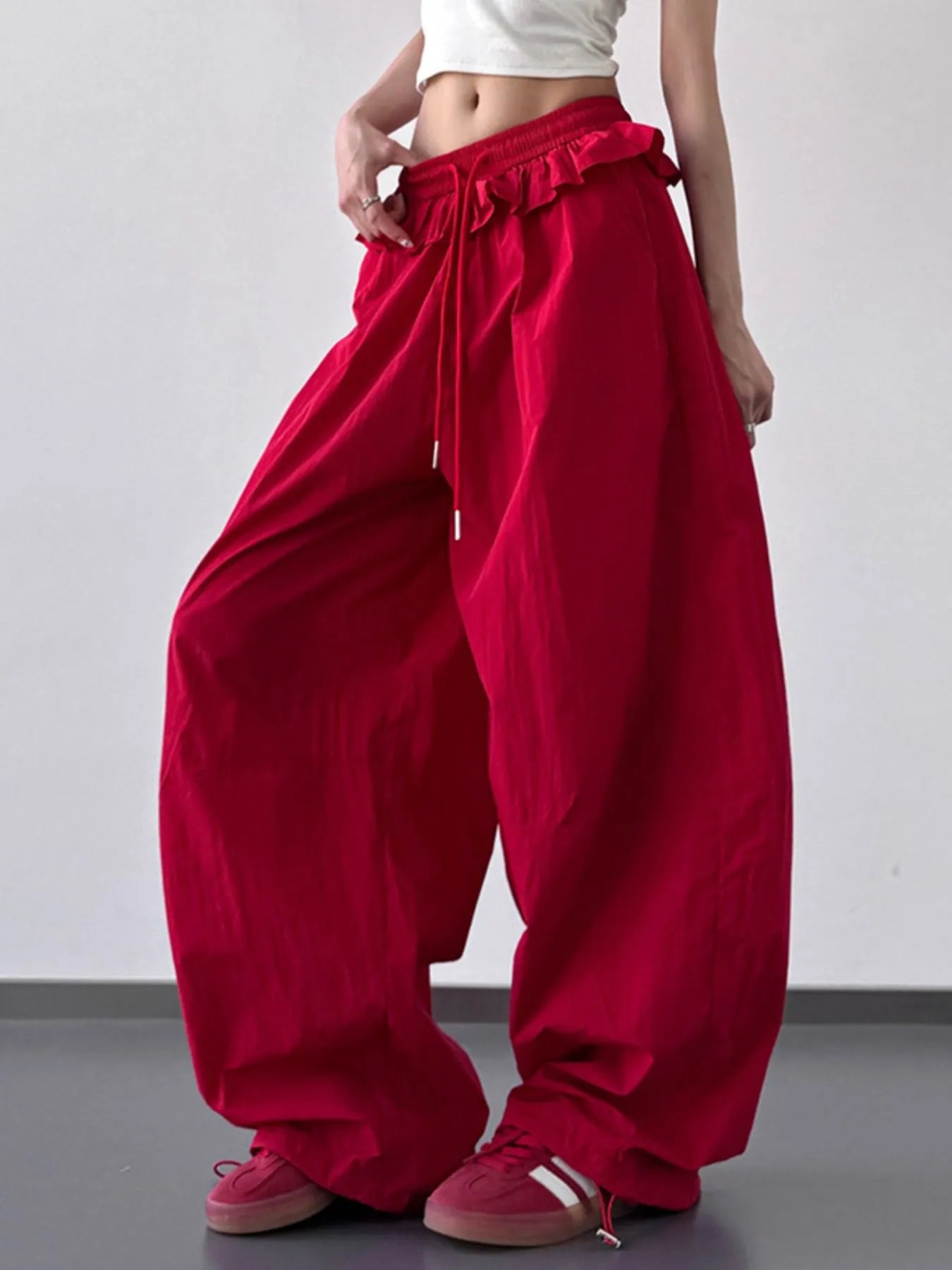Red drawstring wide-leg pants with ruffled waistband and side pocket seams
