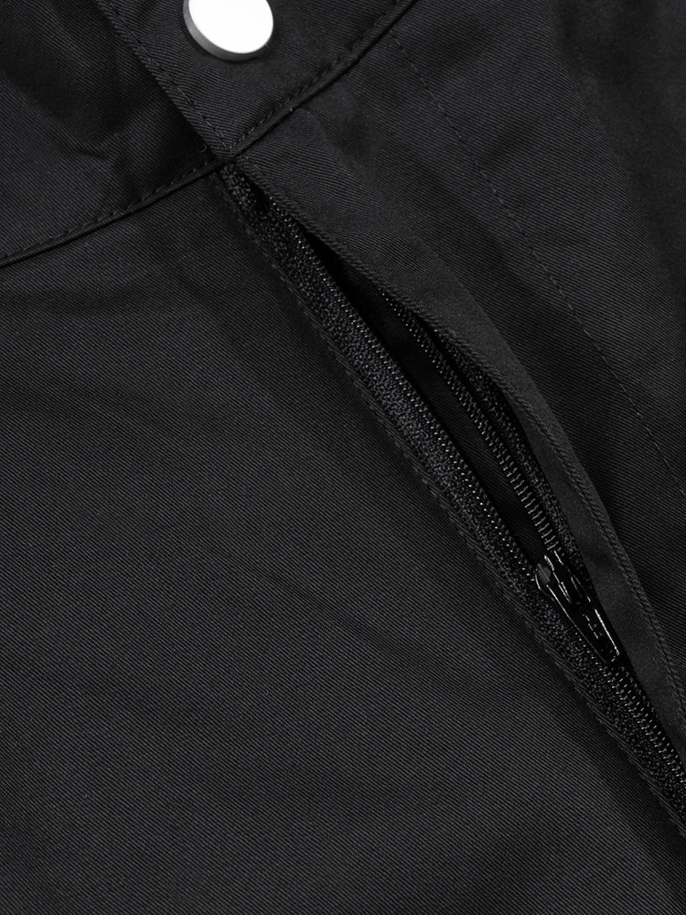 Black zipper pocket close-up on cargo pants with double zipper pulls.