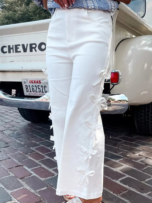 White wide-leg pants with bow accents down the leg
