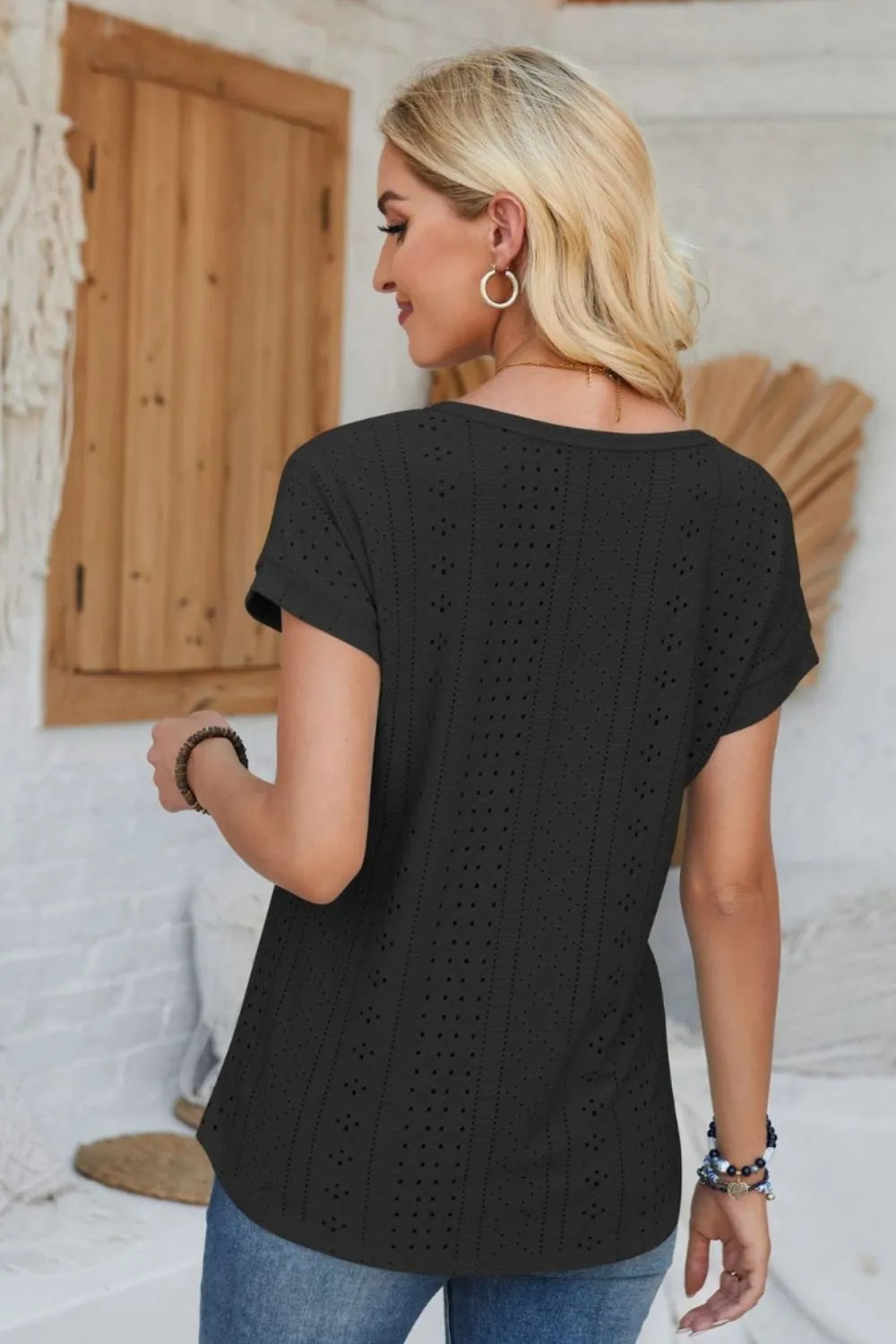 Eyelet round-neck rolled short-sleeve T-shirt in black, rear view with vertical cutouts