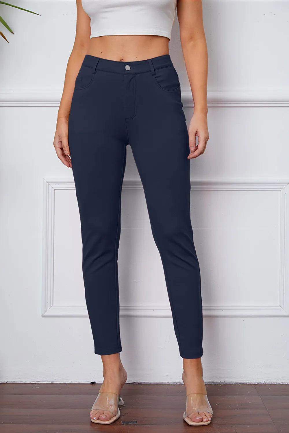 Stretchy dark blue pants with button closure and slim ankle-length tapered leg