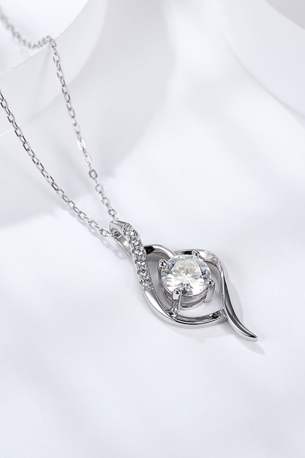 Silver moissanite pendant necklace with round center stone in swirl frame on chain