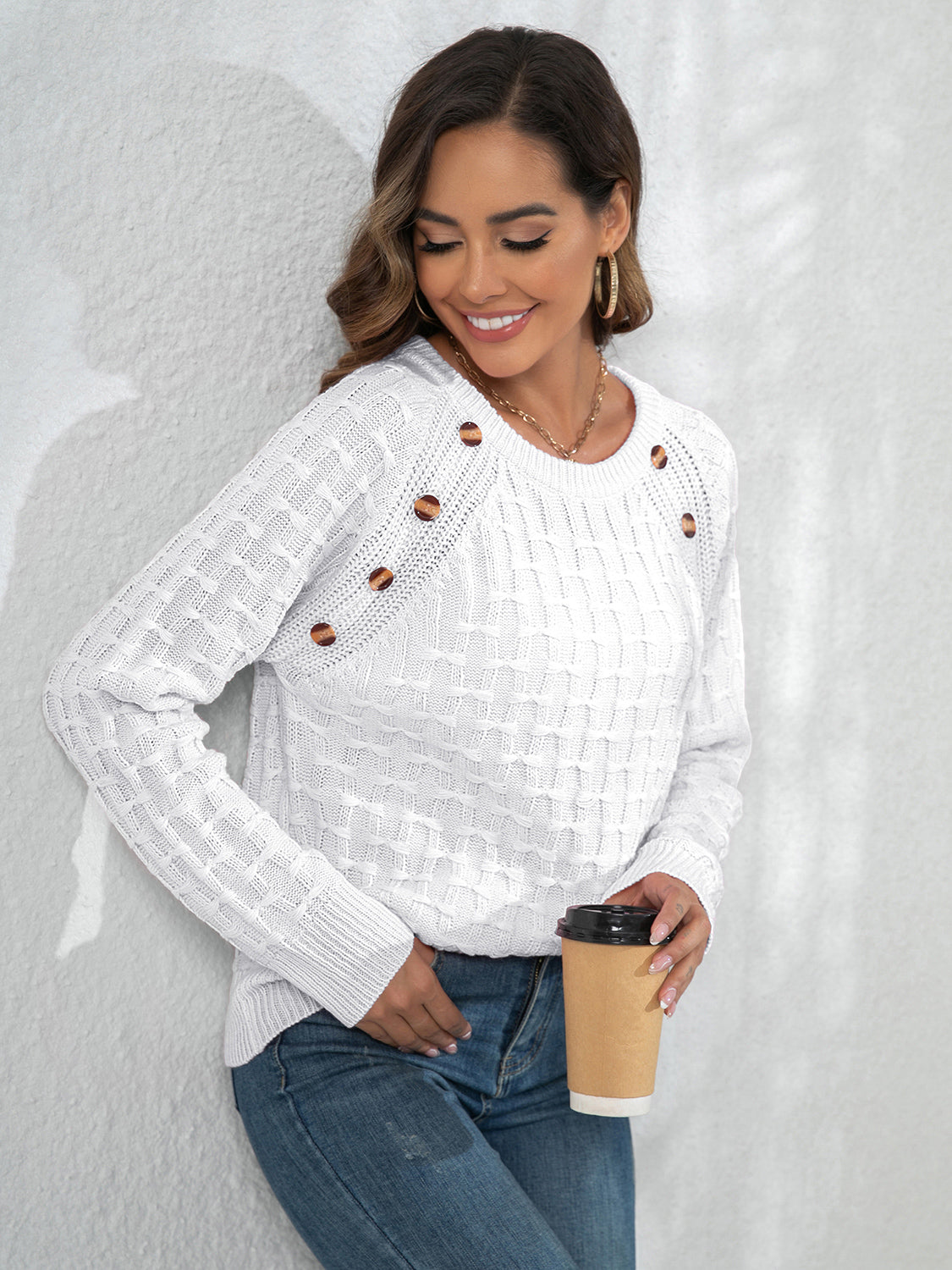 White long-sleeve sweater with textured knit and decorative button placket