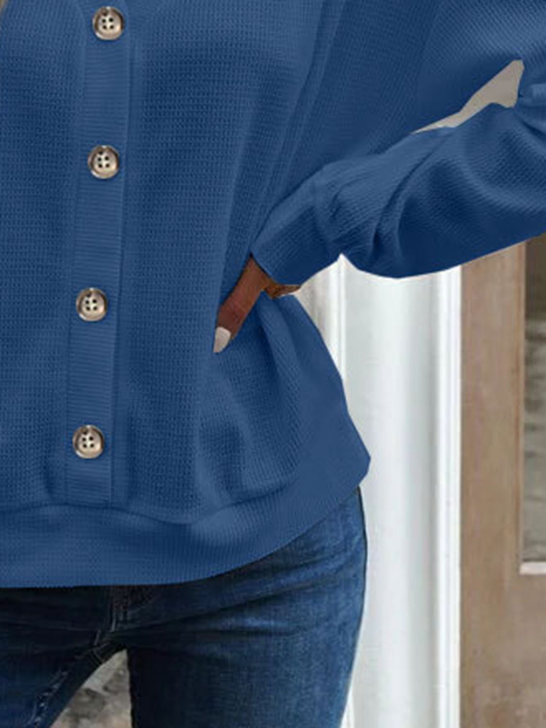 Blue blouse close-up: front button placket and drapey dropped-shoulder sleeve
