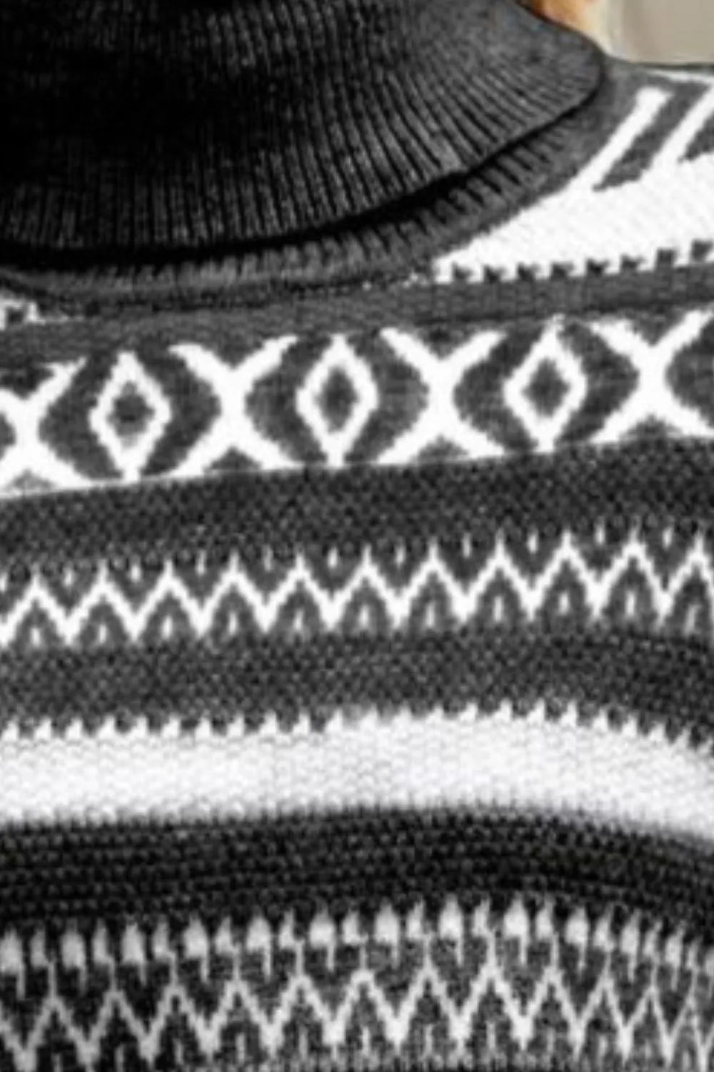 Geometric knit turtleneck close-up in black, white, and light gray stripes