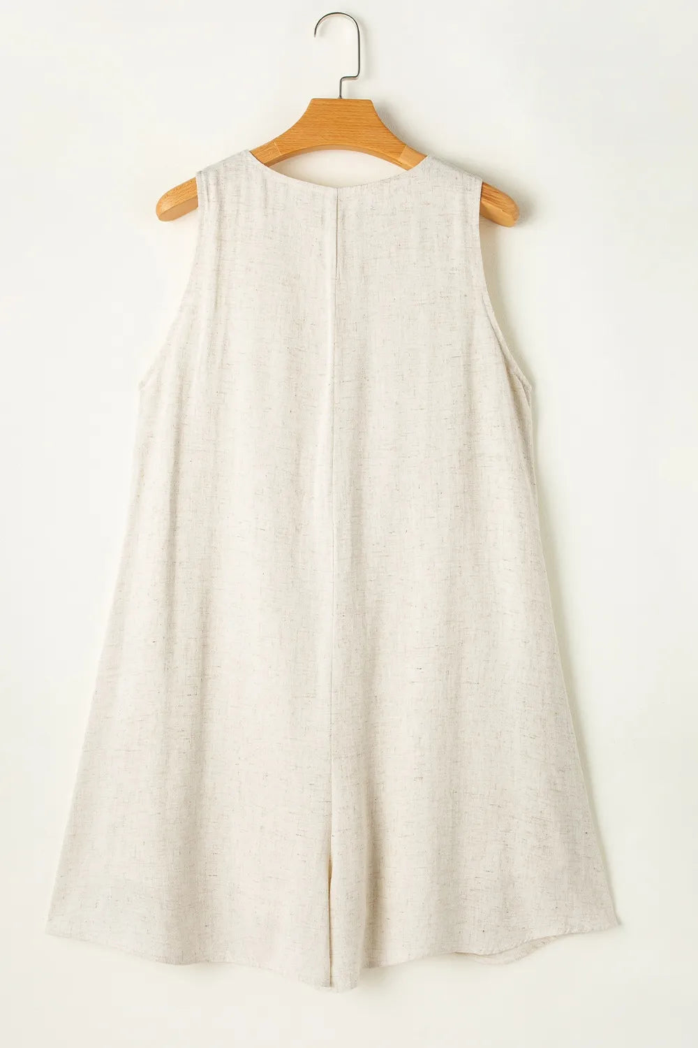 Light beige sleeveless romper with open back and yoke seam