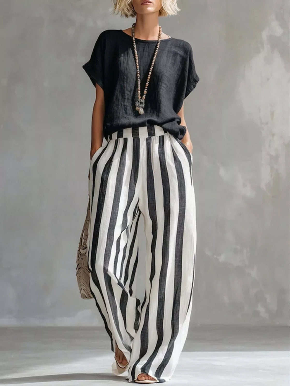 Black short-sleeve top with loose wide-leg pants featuring vertical black-and-white stripes