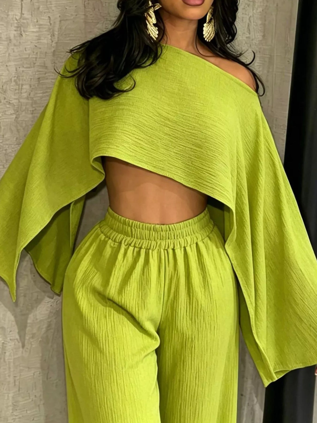 Lime green boat-neck crop top and wide-leg pants set with loose cape sleeves and elastic waist
