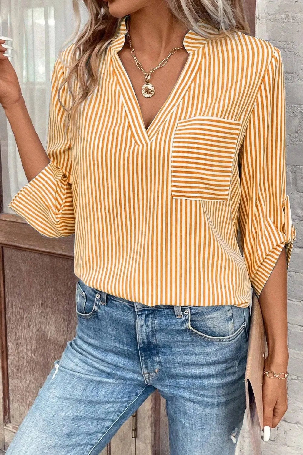 Gold and white striped notched V-neck shirt with chest pocket and roll-tab sleeves