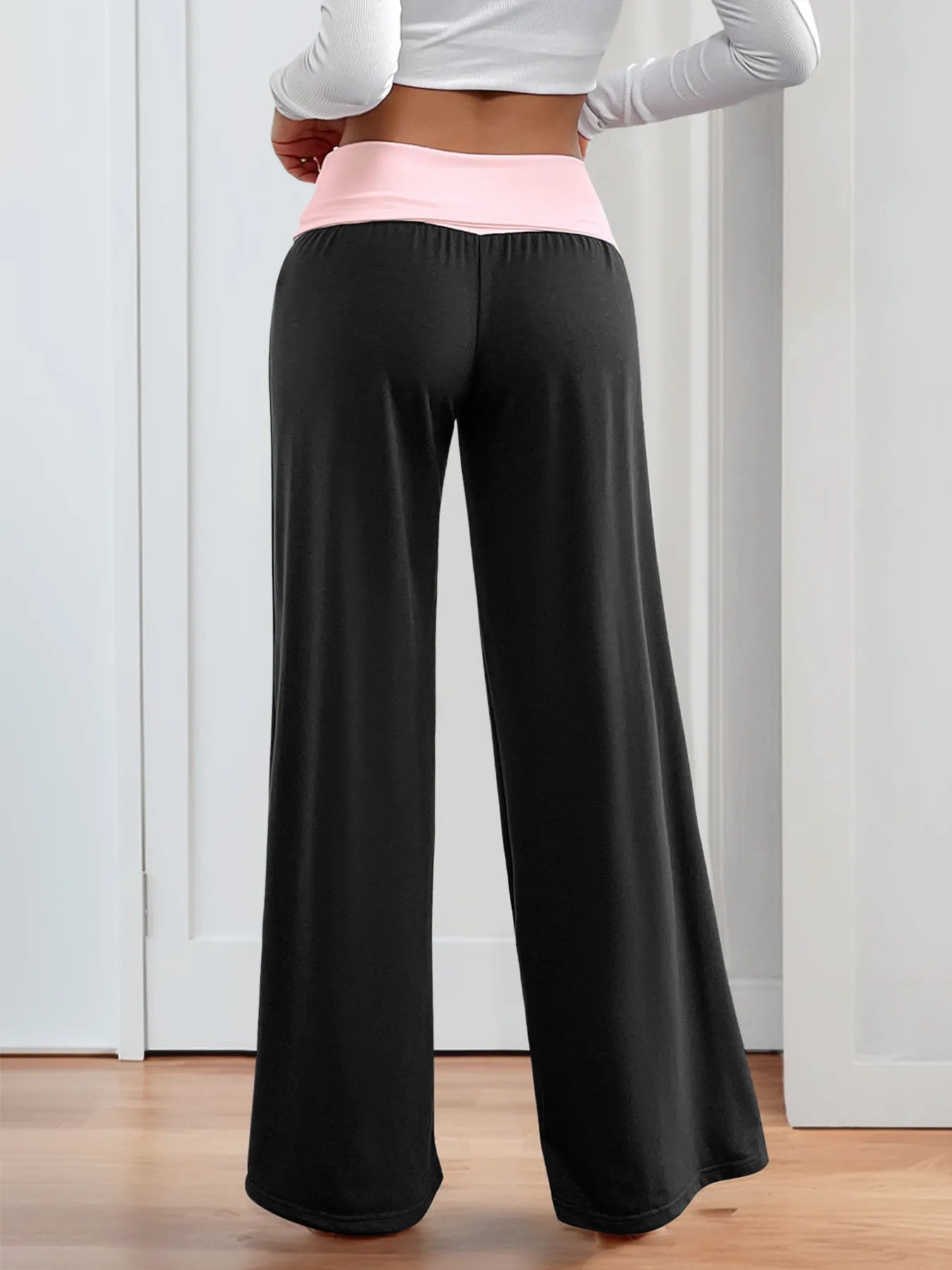 Black wide-leg pants with elastic waist and contrast pink waistband, front view