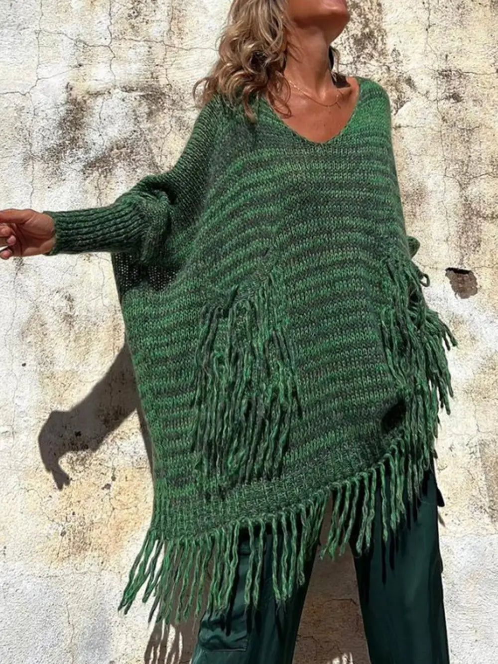 Dark green long-sleeve sweater with fringe hem, knit pocket panels, and scoop neck.
