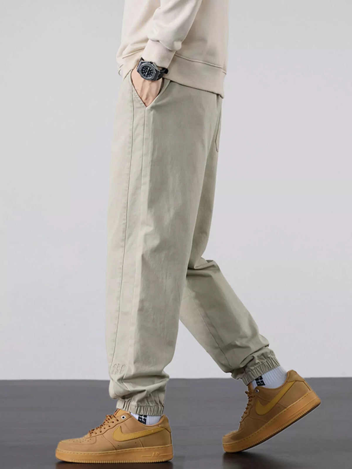 Men's casual light khaki joggers with tapered legs, pockets, and cuffed hem