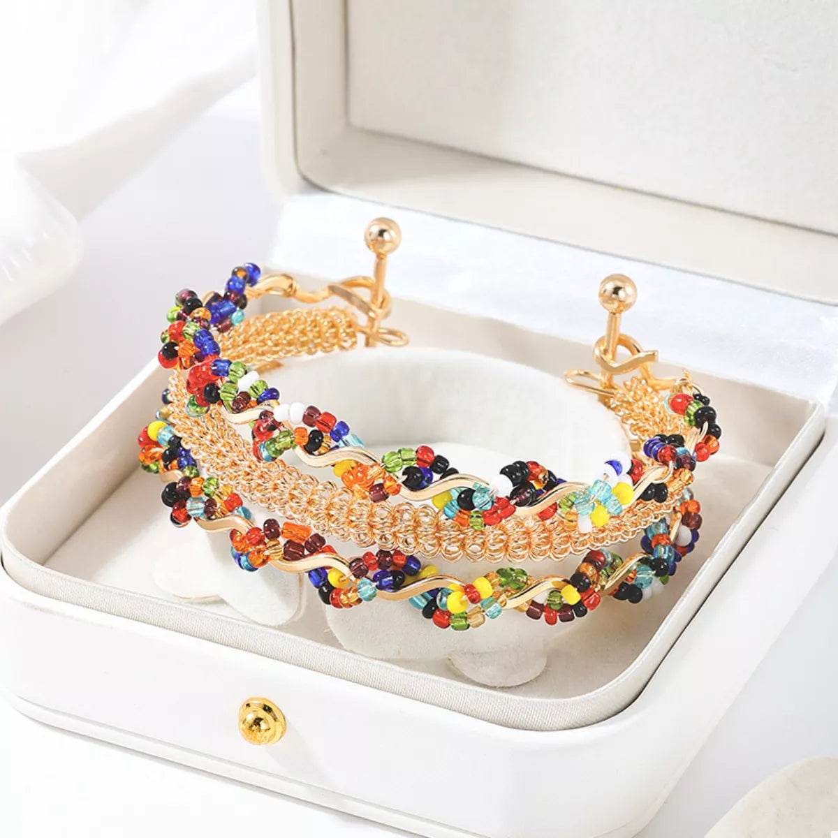 Gold-tone open beaded bracelet with three chain rows in jewelry box