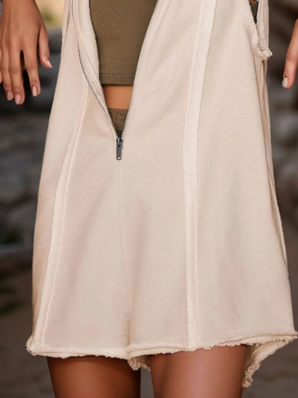 White hooded sleeveless romper with half-zip front and raw-edge hem