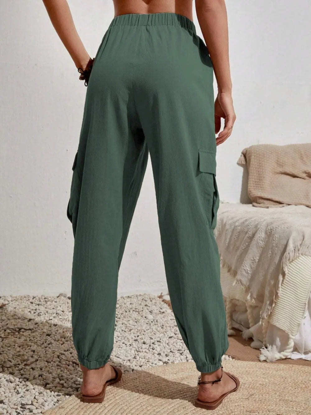 Dark green drawstring cargo joggers with side cargo flap pockets and elastic ankle cuffs