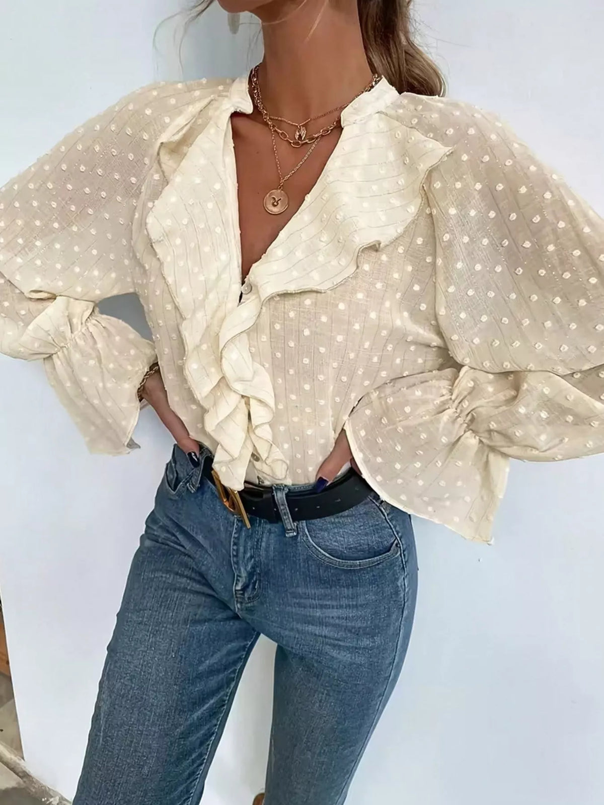 Beige Swiss-dot blouse with ruffled button-front, voluminous puff sleeves