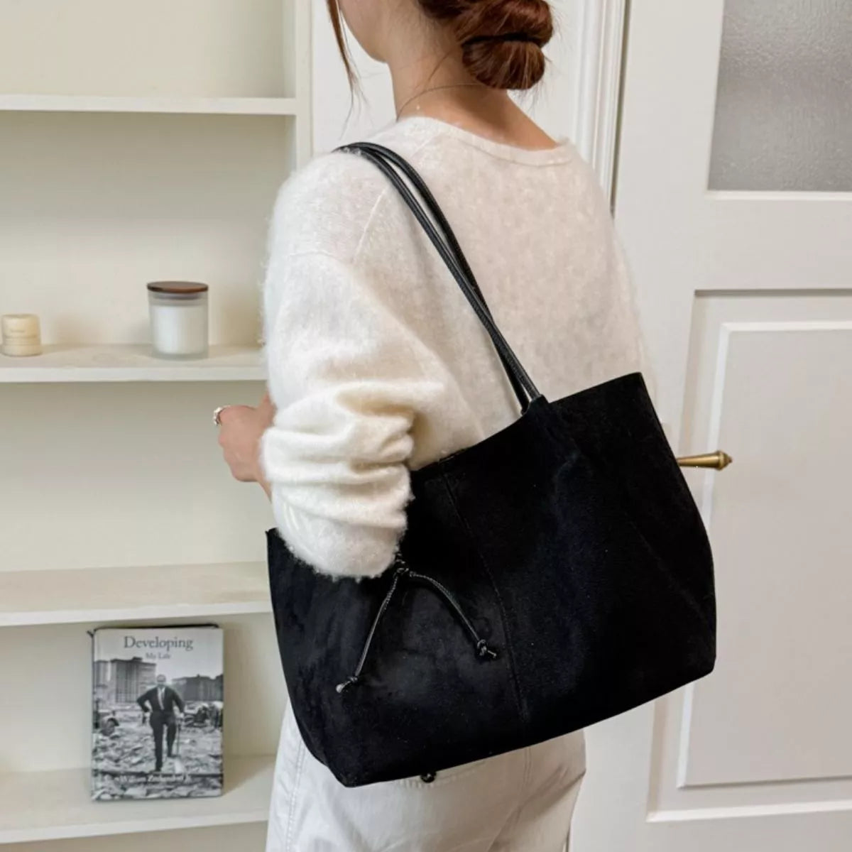 Black suede tote bag with two handles and front drawstring pocket