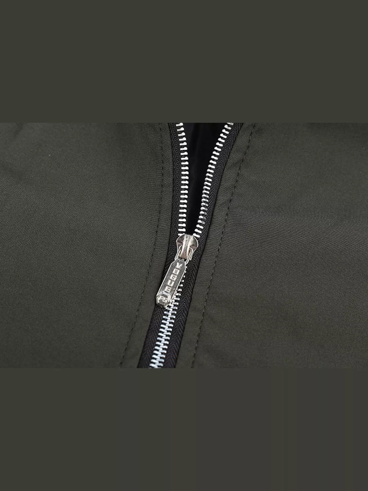 Lightweight men’s bomber jacket zipper close-up on dark green fabric