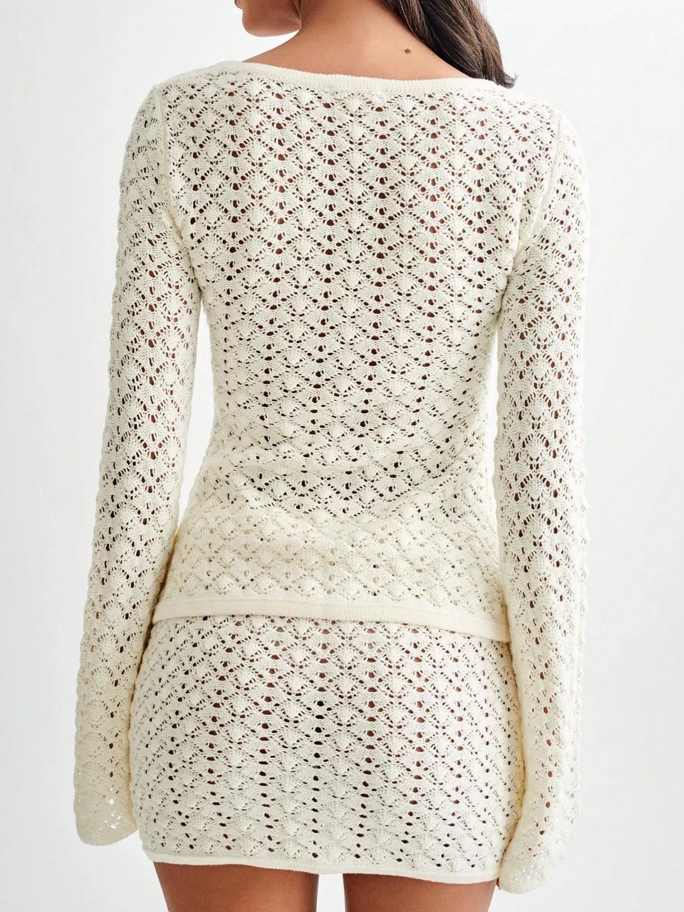Cream crochet button-up cardigan and mini skirt set from back view, textured openwork