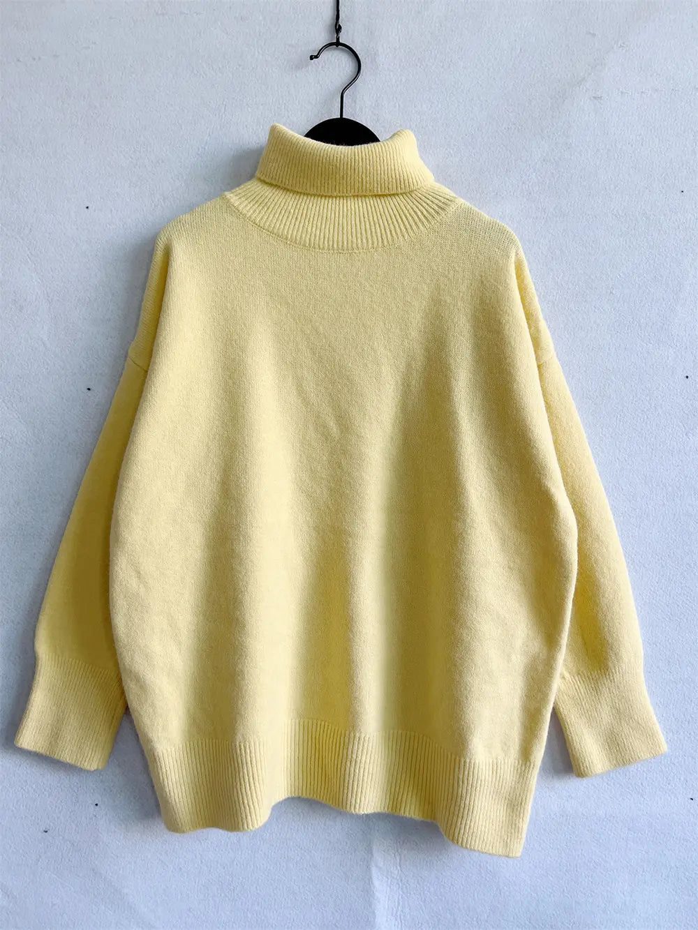 Yellow turtleneck long sleeve sweater on hanger, ribbed collar