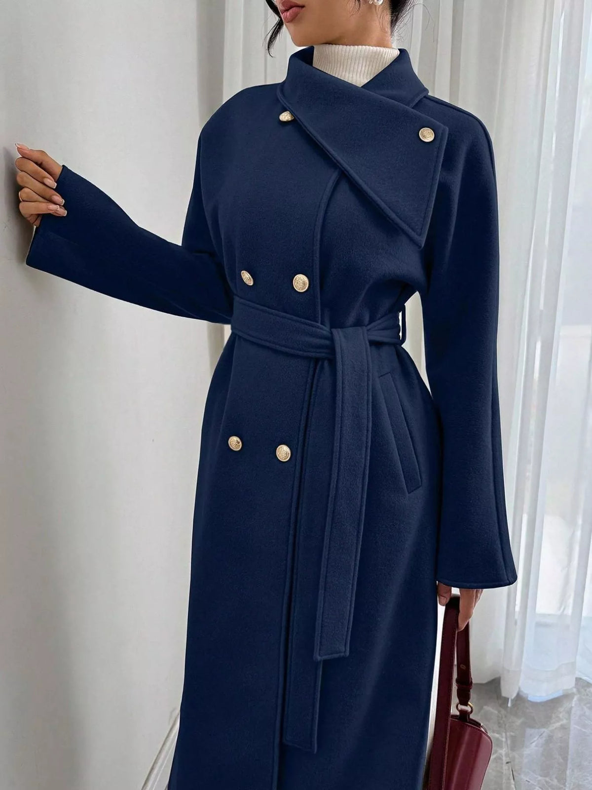 Navy blue longline double-breasted belted coat with gold buttons and wrap collar