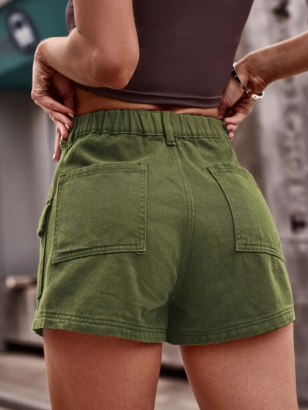 High-waist olive green denim shorts with belt loops, button closure, and two front pockets