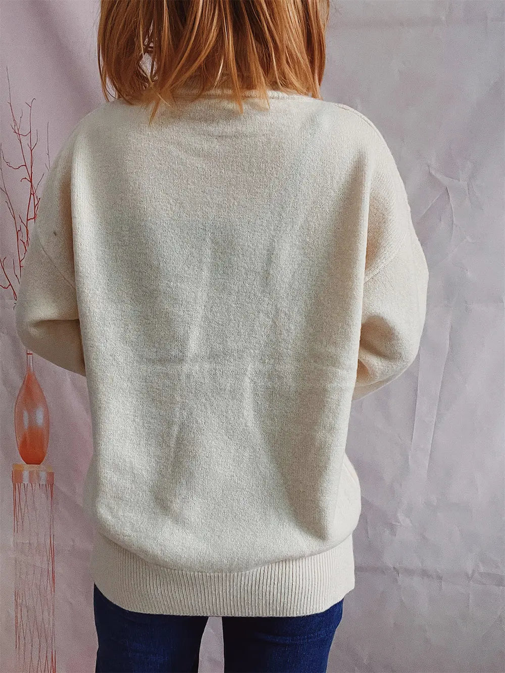 Cream turtleneck long-sleeve sweater, back view with ribbed collar