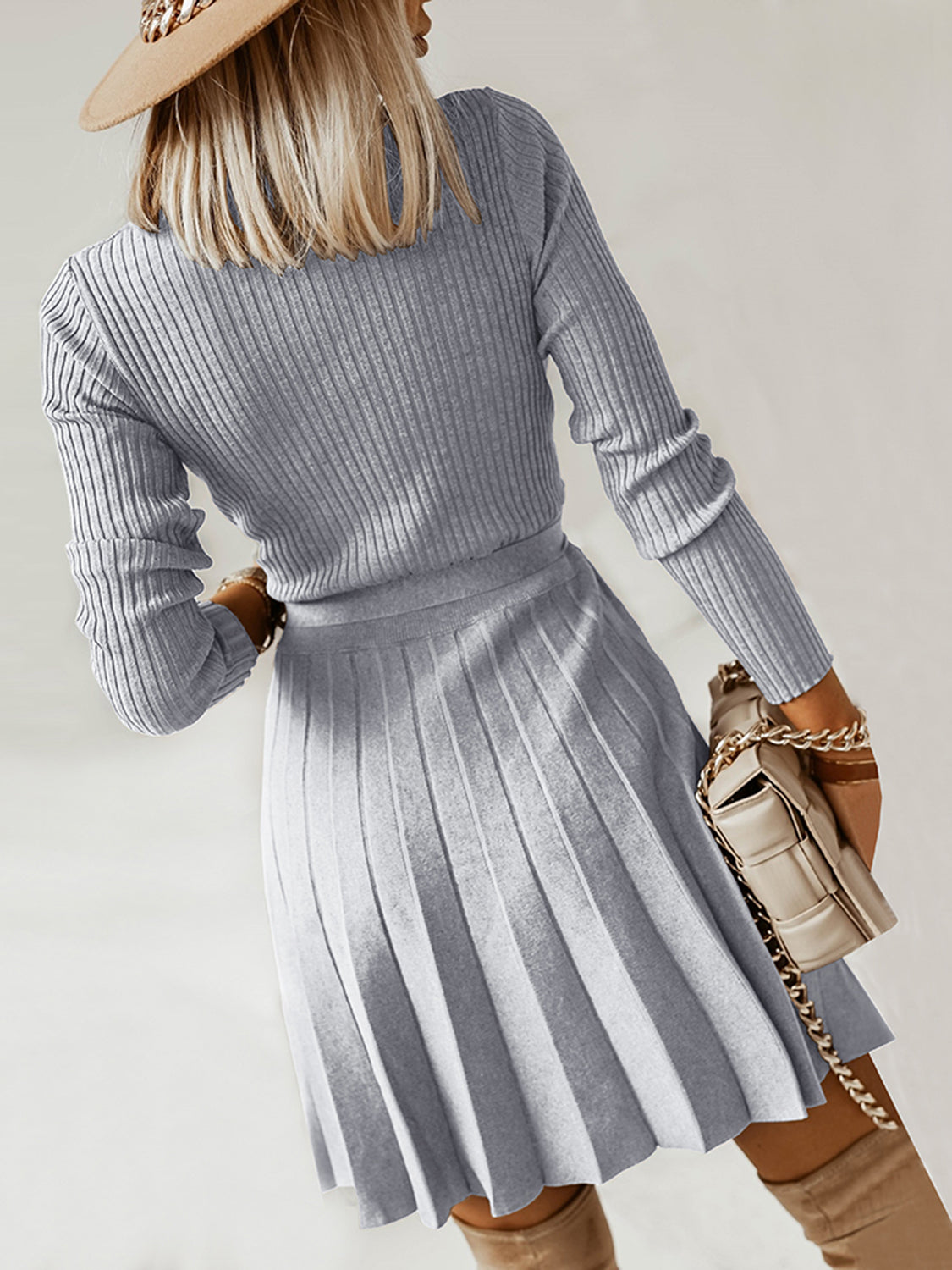 Light gray surplice sweater dress, long sleeves, tie waist, pleated skirt in profile