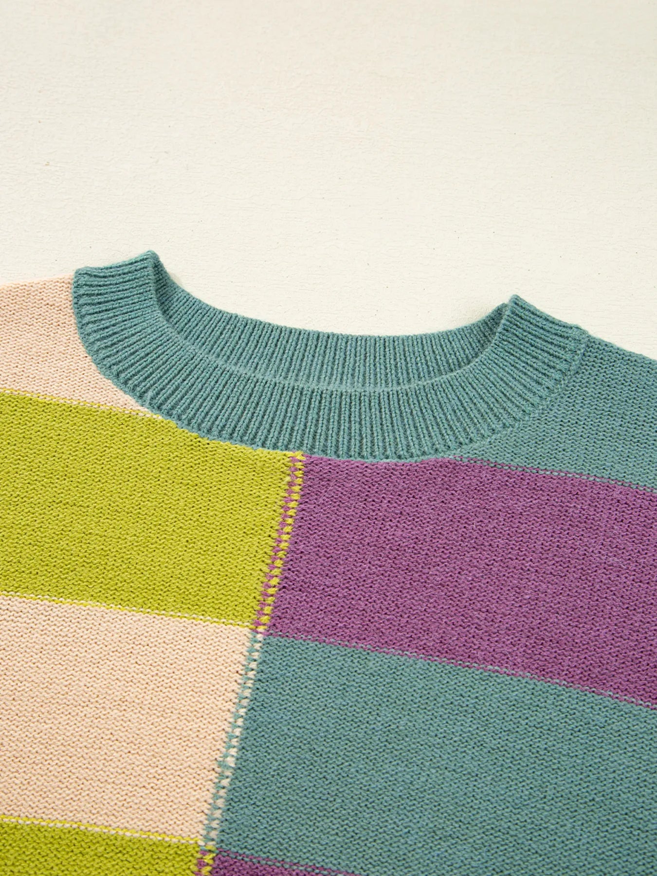 Ribbed crew neckline and multicolor stripe panel on a knit sweater