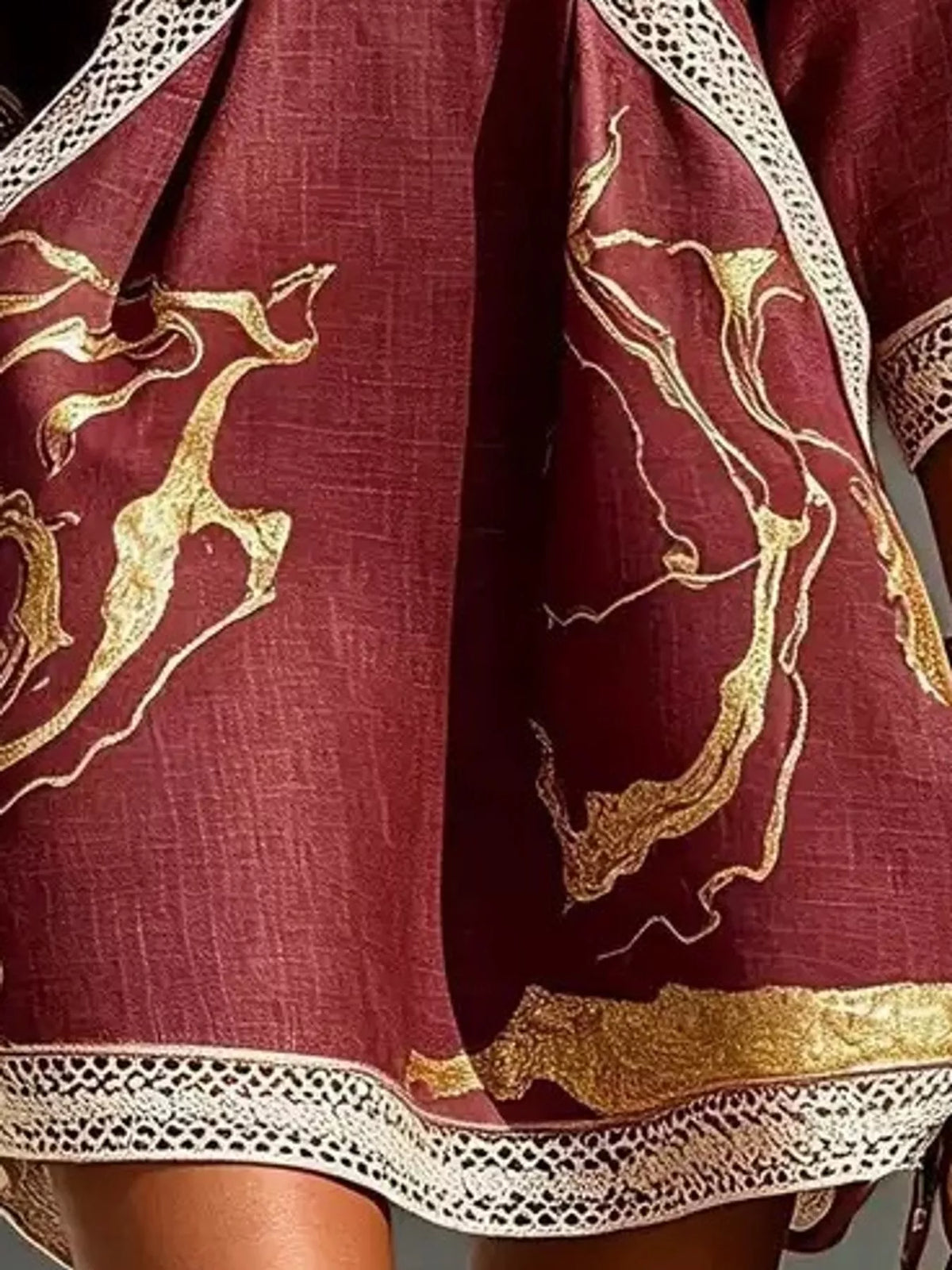 Burgundy mini dress with gold motif print and white lace border hem