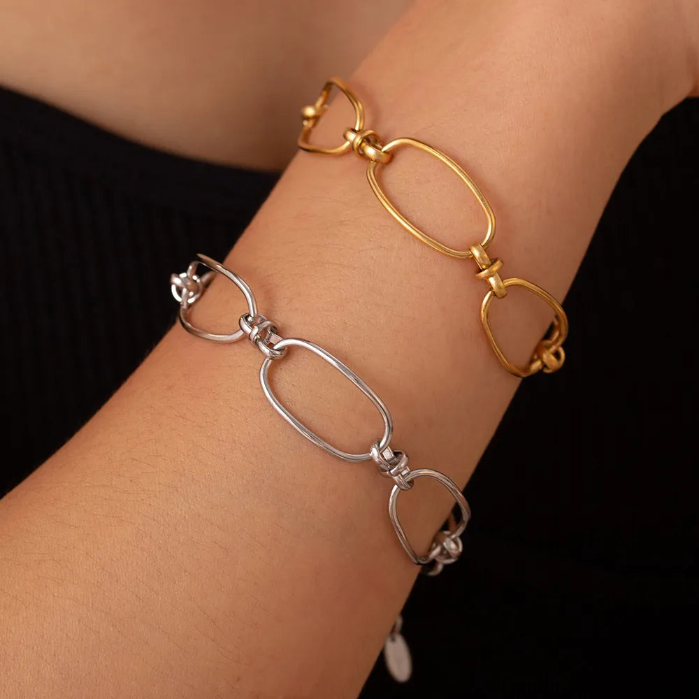 Stainless steel chain bracelet pair on wrist, gold and silver oval links