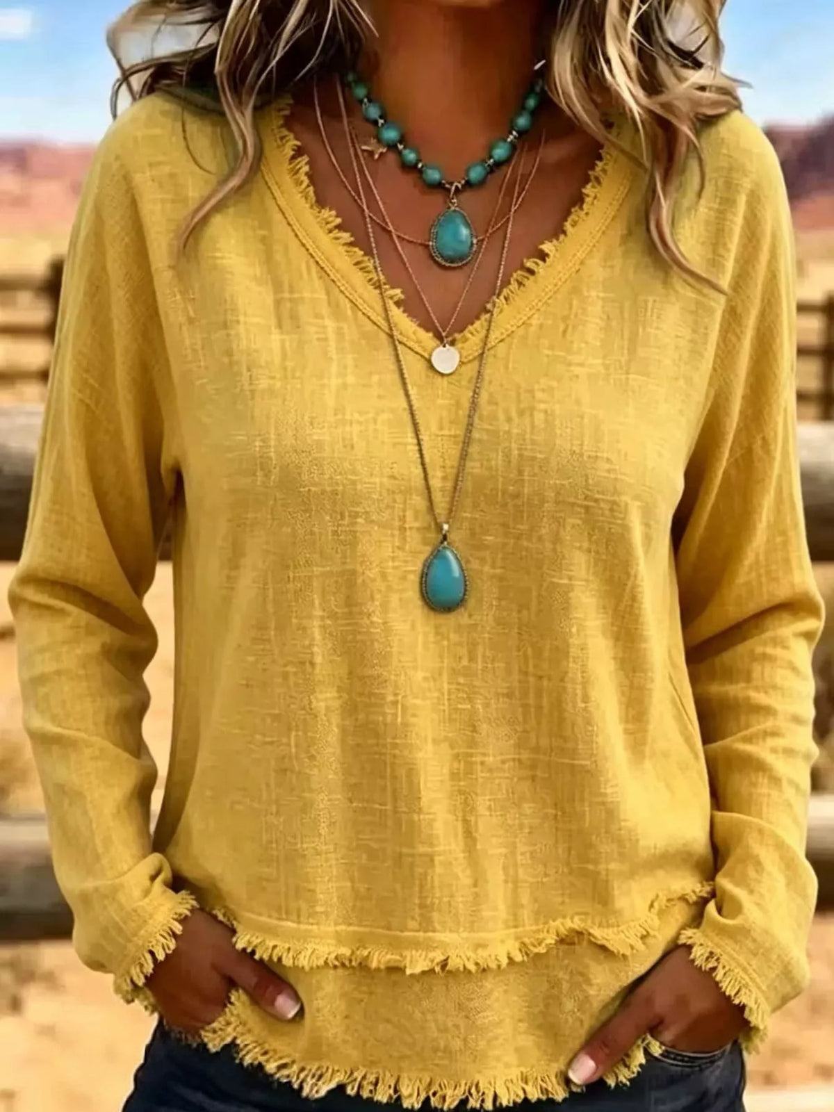 Yellow v-neck relaxed blouse with frayed hem and long sleeves