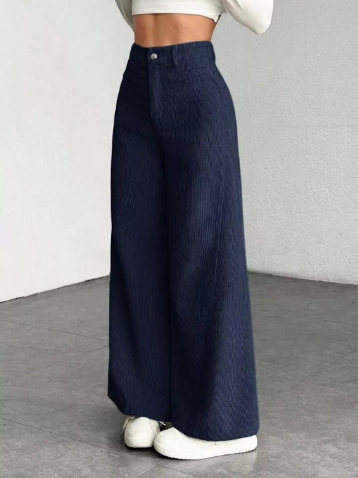 High-waisted wide-leg pants in navy with front pockets and button closure.
