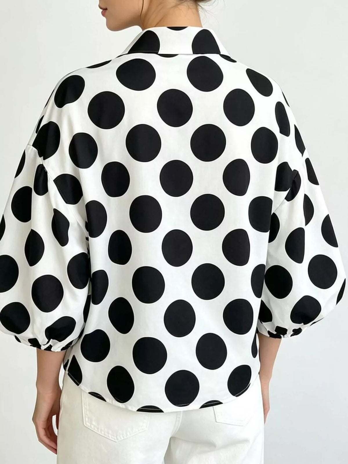 Back view: white polka dot button-front shirt with puff sleeves