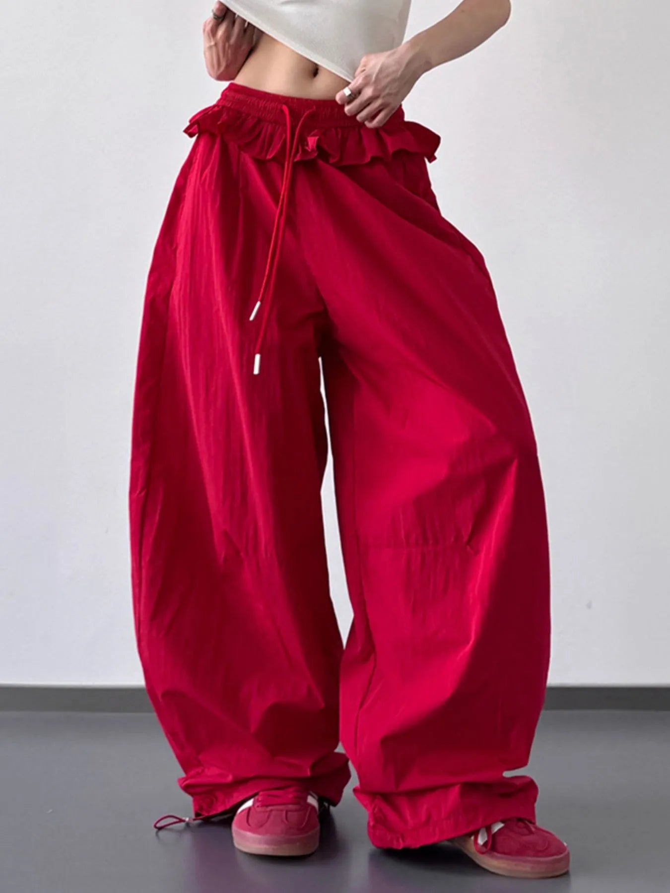 Red drawstring wide-leg pants with ruffled waistband and gathered leg cuffs