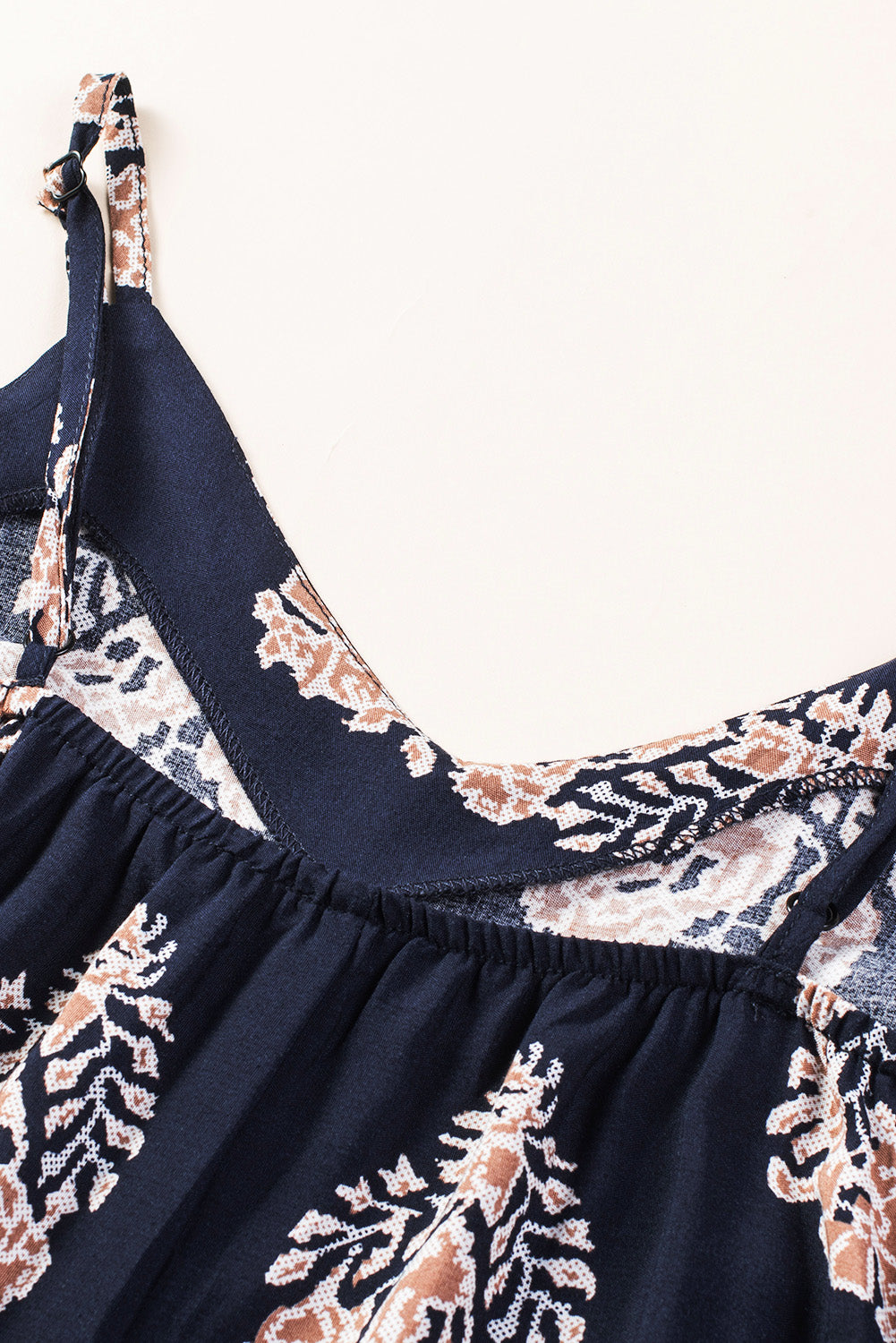 Dark blue printed jumpsuit with V-neck trim and gathered waist detail