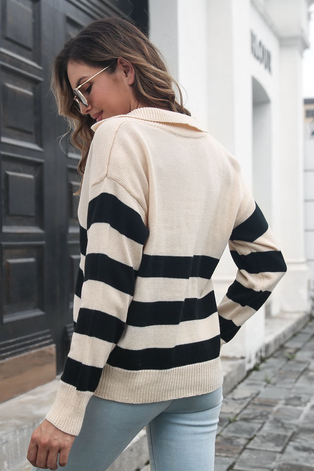 Beige striped knit sweater with black horizontal bands, ribbed back hem