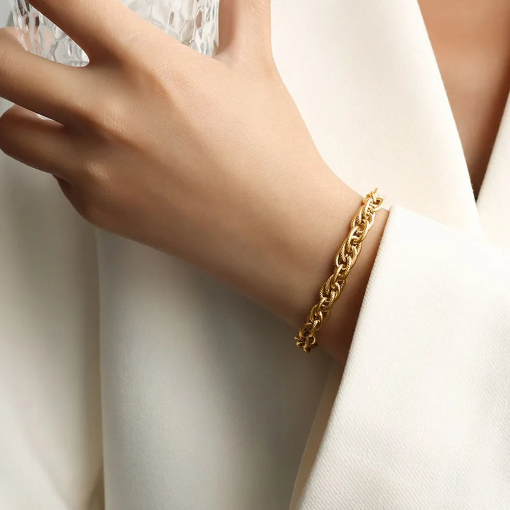 Gold chain bracelet with interwoven links on wrist