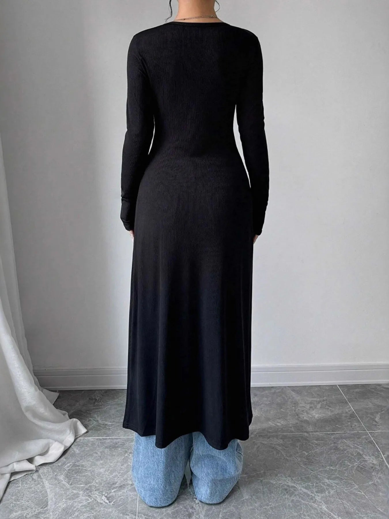 Longline cardigan in black, back view with long sleeves and flowing long hem
