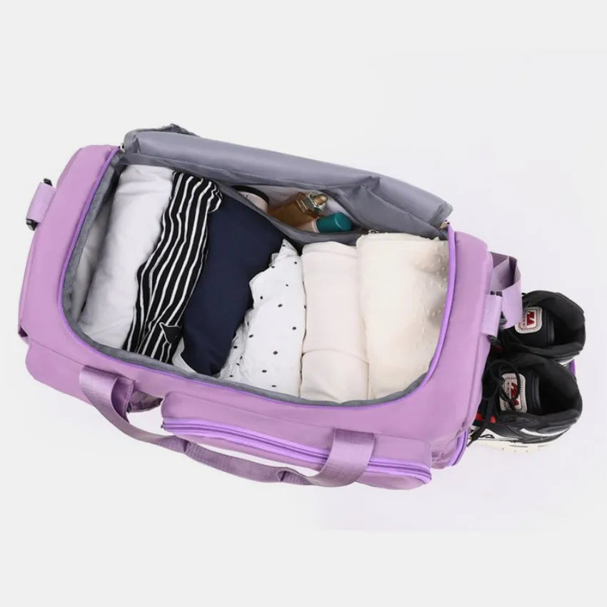 Large travel duffle bag open top view with purple lining and organizers inside.