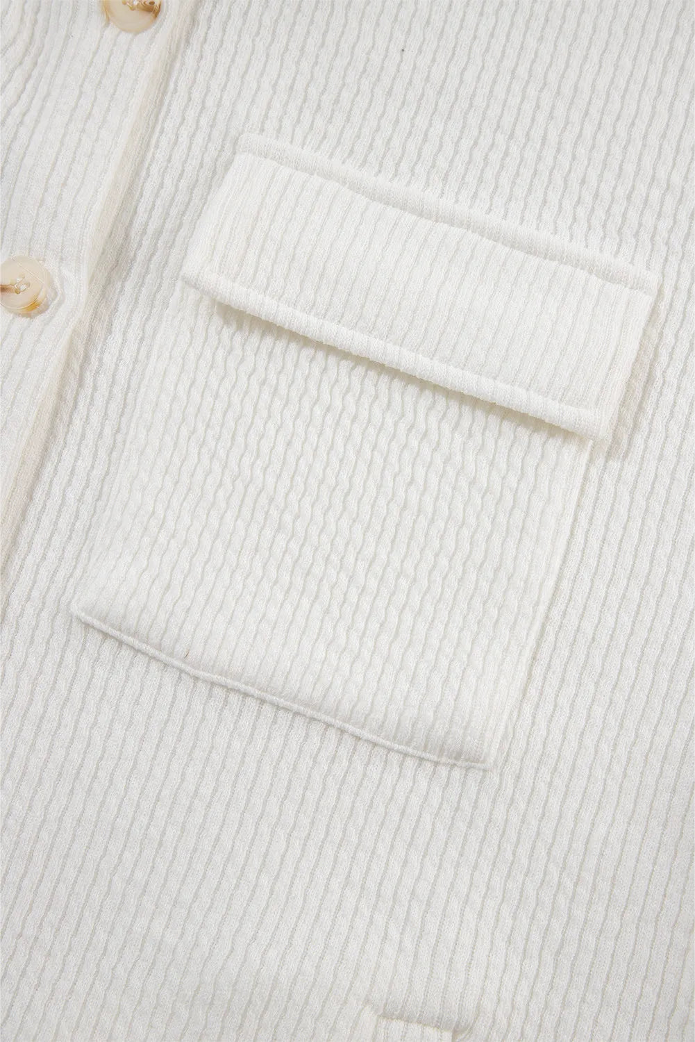 White shacket chest pocket detail with flap and button placket.