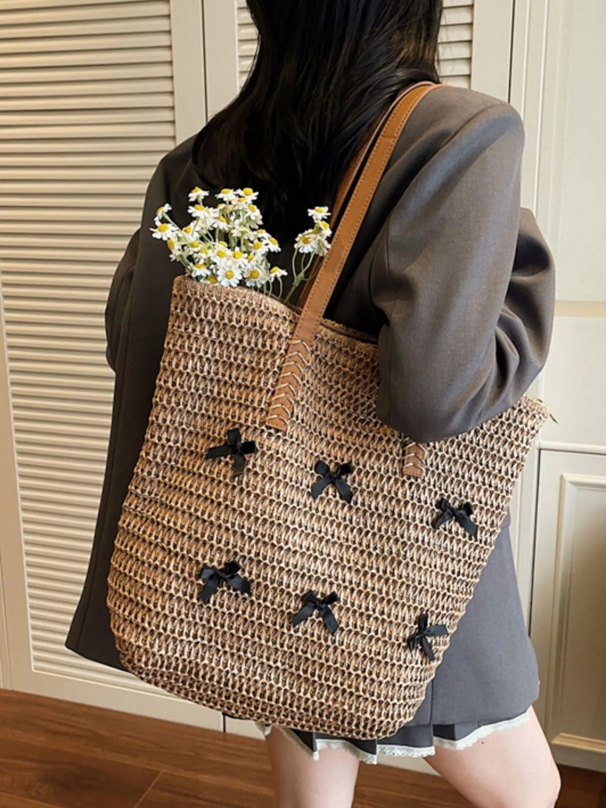 Caramel woven straw tote with bow applique pattern and top flower arrangement
