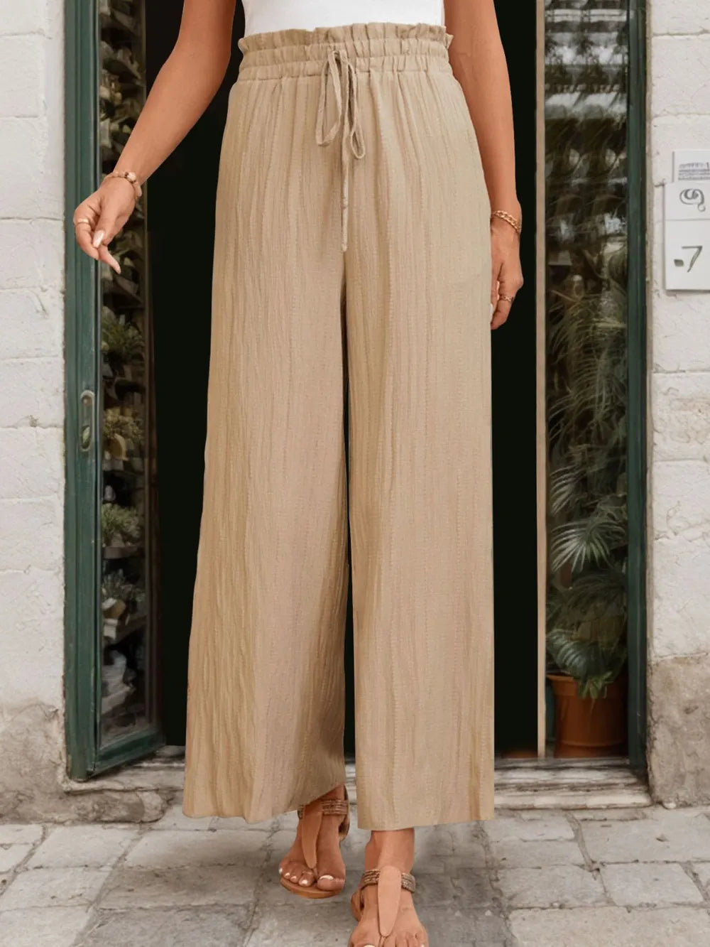 Tan wide-leg pants with drawstring at elastic waist, relaxed straight fall.