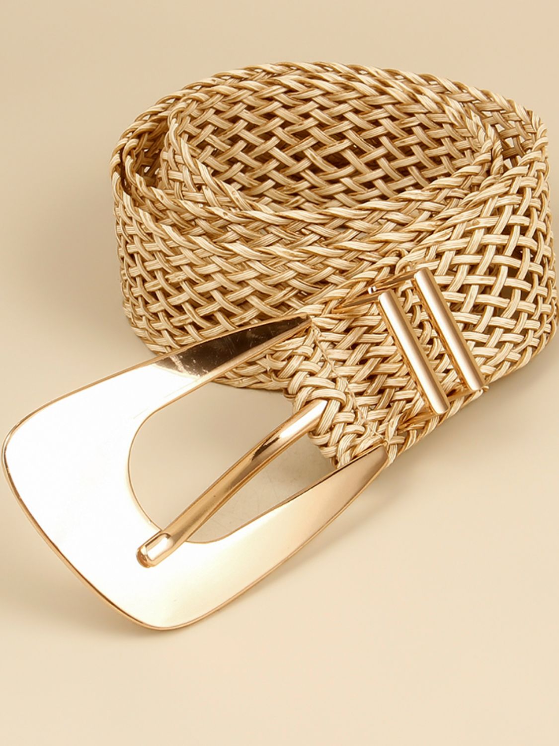 Gold braided belt with irregular buckle and bar frame, close-up