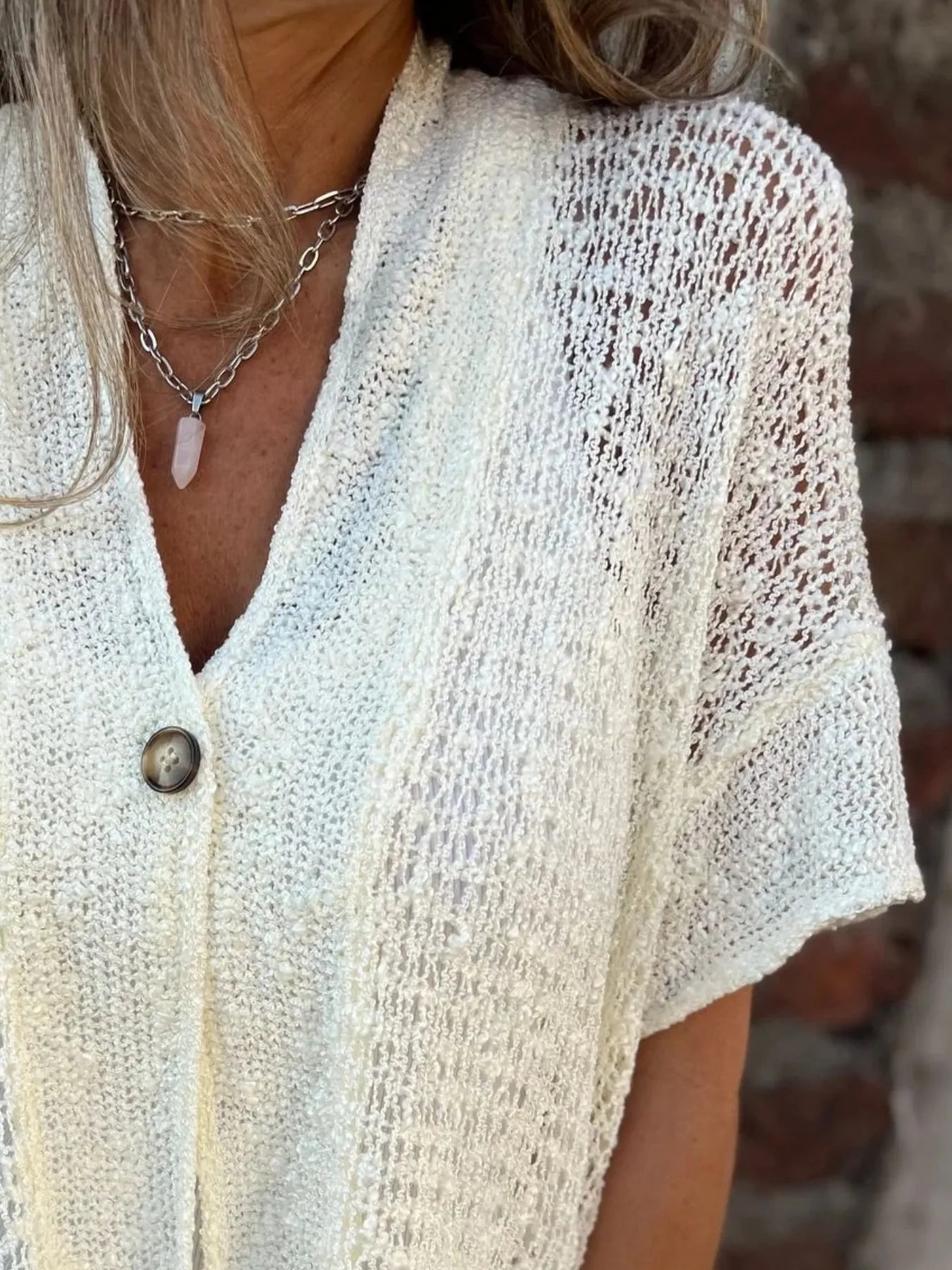 White openwork one-button cardigan with V-neck and short sleeves, textured knit pattern