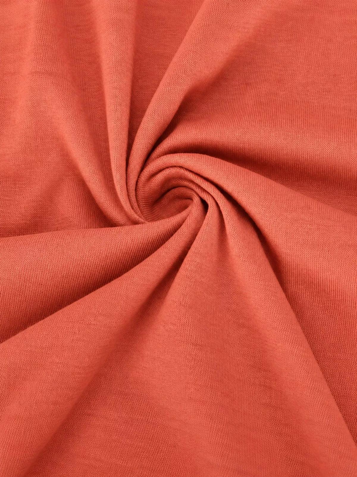 Coral textured fabric close-up with soft, swirling folds
